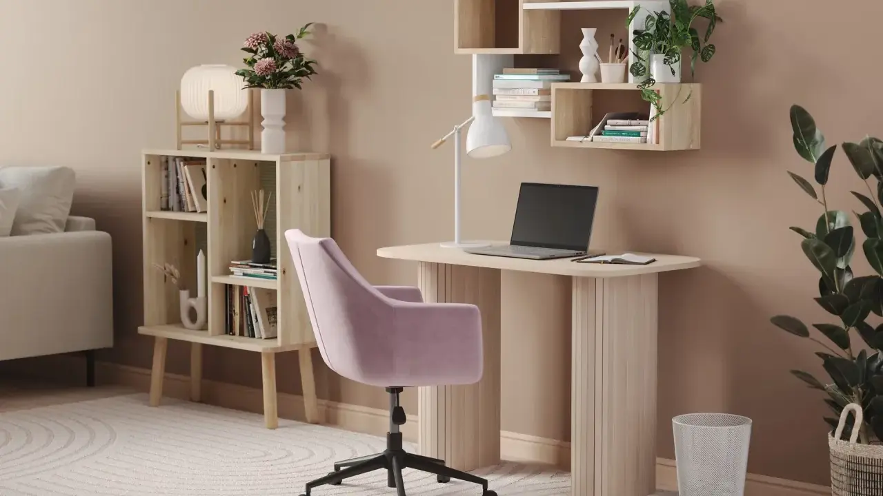 Skrivbord inspo: Ett ljust skrivbord med laptop, en rosa stol och hyllor med växter och böcker. En mysig arbetsplats.