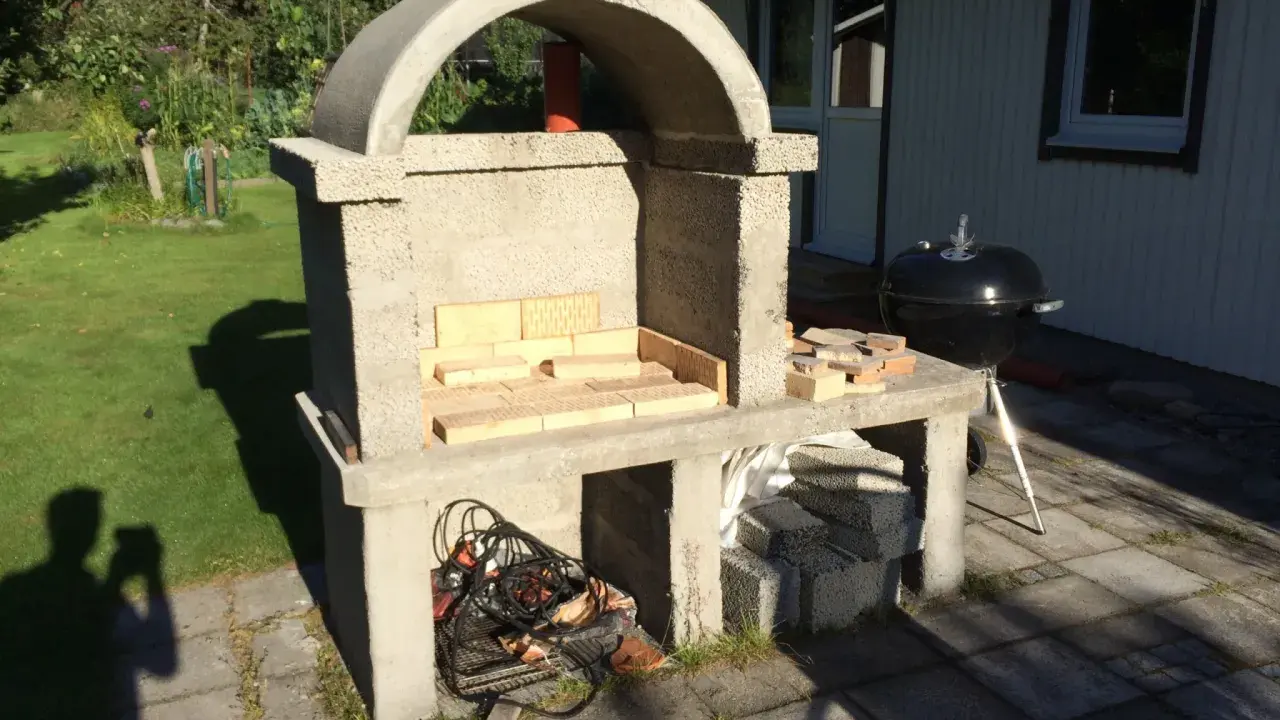 Bygga grill av tegelstenar. En nybyggd betonggrill med tegelstenar i eldstaden, redo för sommarens grillfester.