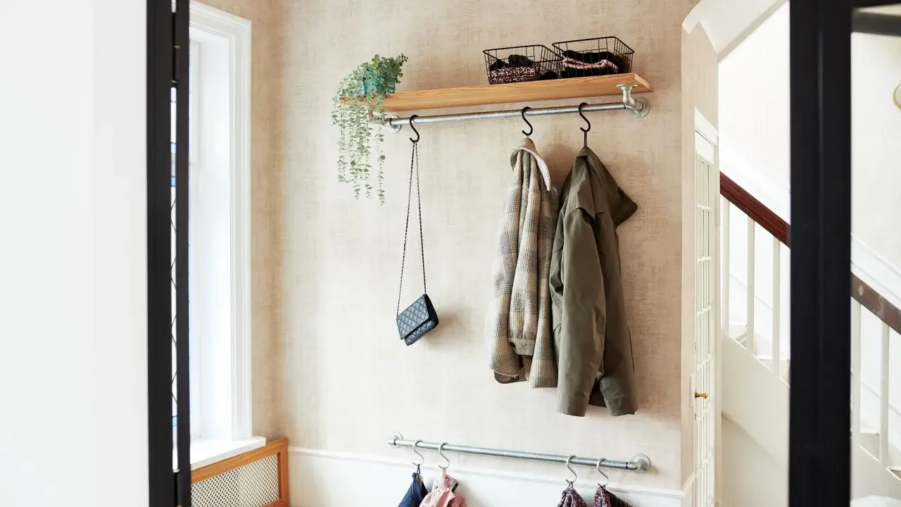 Liten hall inspiration med klädhängare, hylla med korgar och en väska. Perfekt för att hålla ordning.