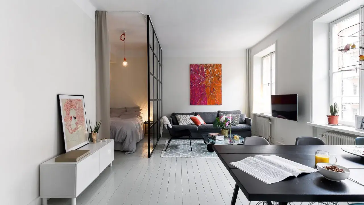 Ljus och modern lägenhet med avdelat sovrum bakom glasvägg. Perfekt kattvind inspiration för små utrymmen.
