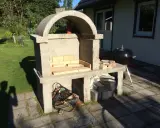 Bygga grill av tegelstenar. En nybyggd betonggrill med tegelstenar i eldstaden, redo för sommarens grillfester.