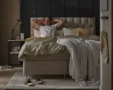 Man sträcker sig i en stor, inbjudande säng. En perfekt start på dagen för att sleepwell.