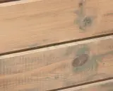 Träpanel med en varm, brun lasyr och inslag av grönaktiga fläckar, som ger en rustik känsla.