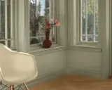 En ljus hall med en vit stol och en vas med blommor på fönsterbrädan. Väggarna är nymålade i en lugn grön nyans.