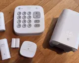Ett eufy larm test med en kontrollpanel, sensorer och en basstation på ett trägolv.