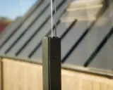 Detaljbild av en stolpe för att montera vindskydd. Glaspanelen syns i bakgrunden.