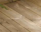 Träaltanen behöver behandlas för att behålla sin lyster. Gröna blad skymtar i övre vänstra hörnet.