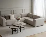 En ljus hörna med en bekväm möbler soffa, kaffebord och blommor.