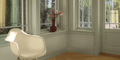 En ljus hall med en vit stol och en vas med blommor på fönsterbrädan. Väggarna är nymålade i en lugn grön nyans.