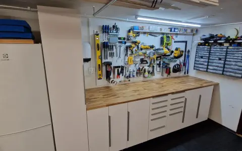 Välordnat garage med verktygstavla, arbetsbänk och förvaringsskåp. Perfekt garage inspiration för den händige.