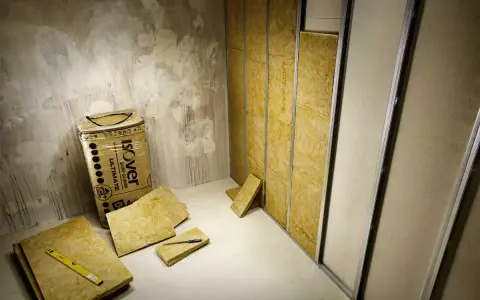 Isolering av glasull pågår. Tänk på att glasull farligt, använd skyddsutrustning vid hantering.