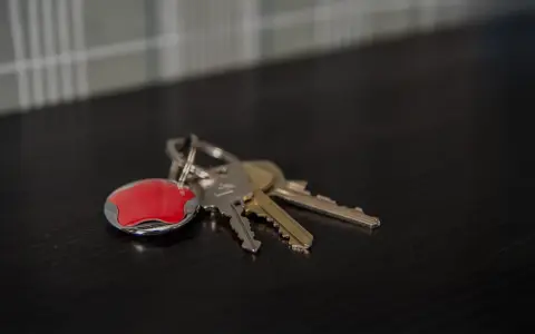Nycklar med en röd Verisure-tagg. Tänk på hur larmar man på Verisure när du lämnar hemmet.