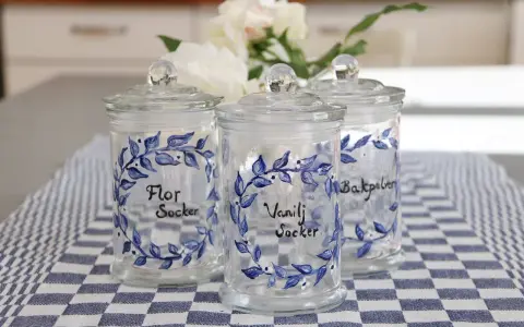 Tre vackra glasburkar med blå blommotiv, perfekta för att måla på glasburkar och förvara socker eller bakpulver.