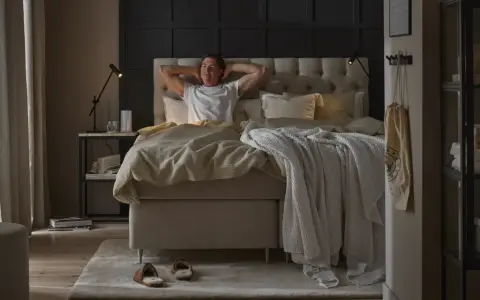 Man sträcker sig i en stor, inbjudande säng. En perfekt start på dagen för att sleepwell.