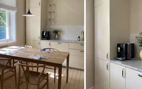 Ljust kök med beige skåpluckor, träbord och stolar. En kaffemaskin står på bänken. Kanske dags att måla luckor för en fräschare känsla?