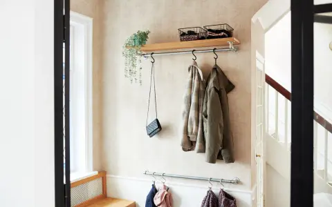 Liten hall inspiration med klädhängare, hylla med korgar och en väska. Perfekt för att hålla ordning.
