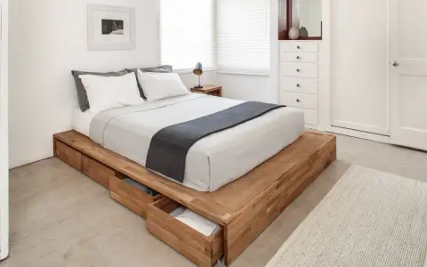 Säng med smart förvaring vid sängen i form av utdragbara lådor i trä. Enkel och stilren design.