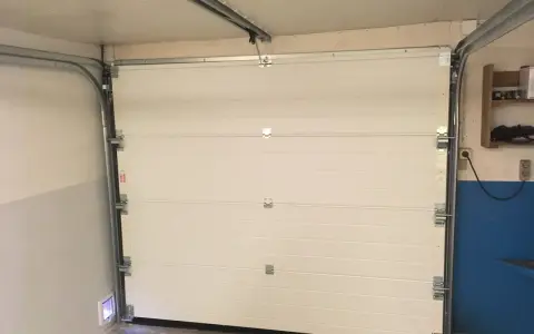 Monterad verisure magnetkontakt på garageporten. Enkel installation för ökad säkerhet.