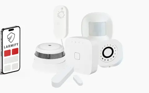 En smartphone med larm appen Larmify bredvid olika säkerhetssensorer som rörelsedetektor och brandvarnare.