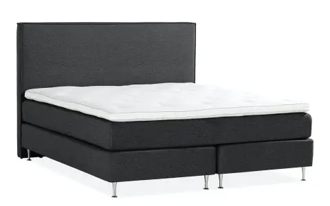 En mörkgrå, modern kontinentalsäng med en vit bäddmadrass och eleganta metallben. Denna elite säng är en dröm för alla som söker komfort.