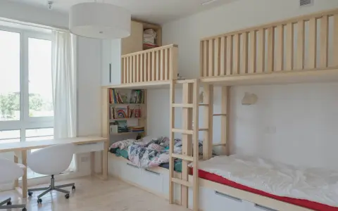Ljust och luftigt barnrum med våningssängar i trä, bokhyllor och skrivbord. Perfekt inspiration barnrum för lek och studier.