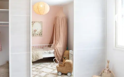 A child's closet with clothes and baskets, a pink bedroom with a bed and canopy, and a white wall with a window.