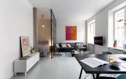 Ljus och modern lägenhet med avdelat sovrum bakom glasvägg. Perfekt kattvind inspiration för små utrymmen.