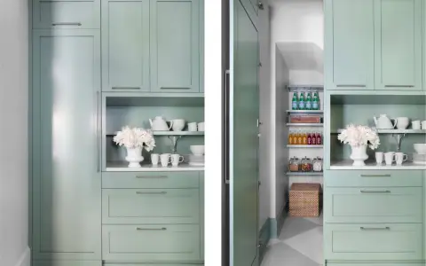En inbyggd walk-in skafferi med mintgröna skåp, hyllor med flaskor och burkar, samt en korg.
