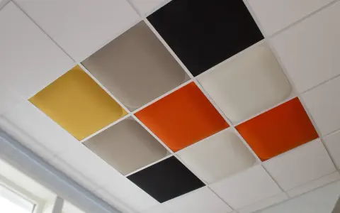Färgglada akustikplattor i ett rutmönster på ett innertak. Enkla att måla innertak plattor för att skapa en unik design.