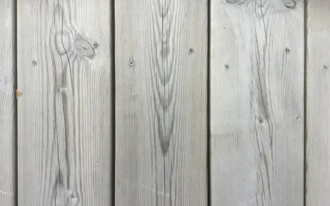 Grå träpanel med tydlig ådring, som efter kiselbehandling altan. Perfekt för en modern och hållbar uteplats.