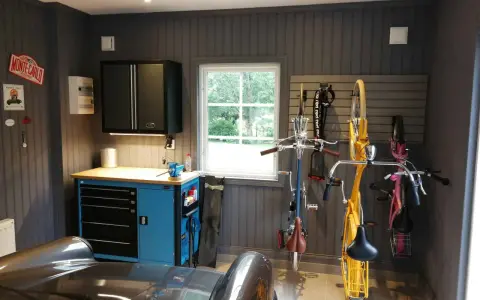 Snygga garage med cyklar upphängda, verktygsskåp och en bil. Perfekt garage inspiration för den som gillar ordning och reda.