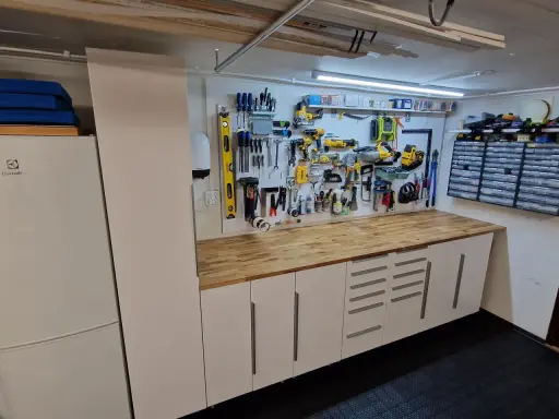 Välordnat garage med verktygstavla, arbetsbänk och förvaringsskåp. Perfekt garage inspiration för den händige.