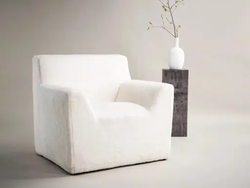 En mysig, vit fåtölj som passar perfekt i ett ungdomsrum. Den inbjuder till avkoppling och läsning.