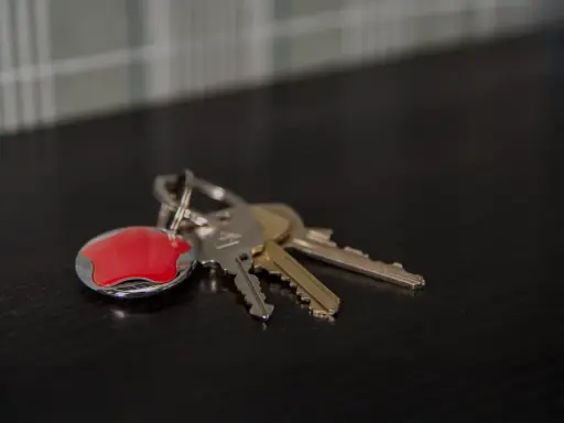 Nycklar med en röd Verisure-tagg. Tänk på hur larmar man på Verisure när du lämnar hemmet.