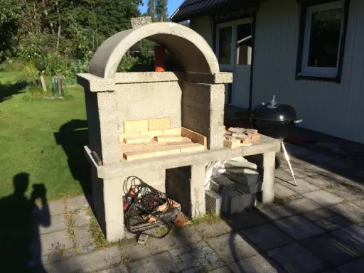 Bygga grill av tegelstenar. En nybyggd betonggrill med tegelstenar i eldstaden, redo för sommarens grillfester.