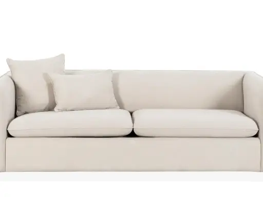 En ljusbeige bäddsoffa med två kuddar. Perfekt för gäster eller en mysig kväll.
