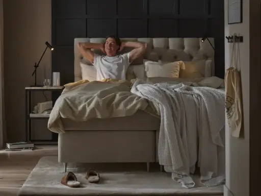 Man sträcker sig i en stor, inbjudande säng. En perfekt start på dagen för att sleepwell.