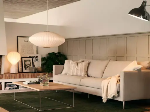 En inbjudande soffgrupp med en bekväm soffa, ett lågt soffbord och en mysig brasa.