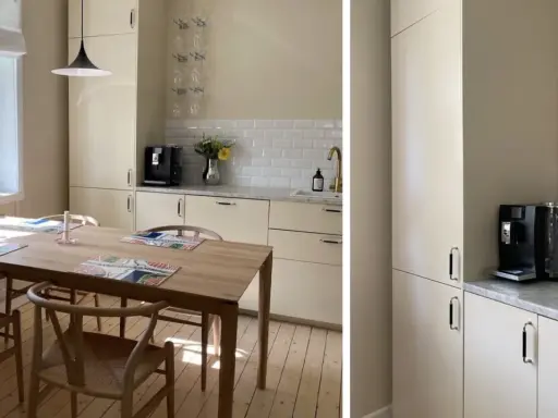 Ljust kök med beige skåpluckor, träbord och stolar. En kaffemaskin står på bänken. Kanske dags att måla luckor för en fräschare känsla?
