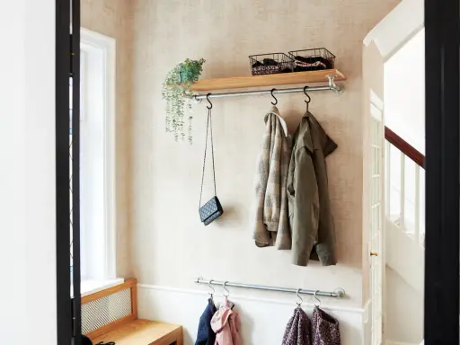 Liten hall inspiration med klädhängare, hylla med korgar och en väska. Perfekt för att hålla ordning.