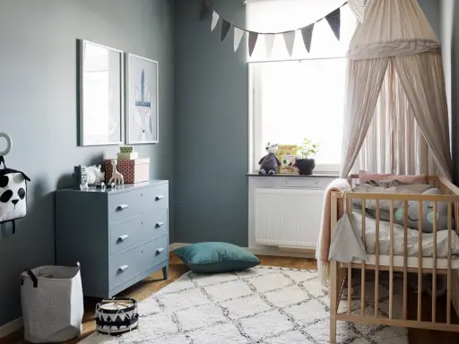 Mysigt barn sovrum med spjälsäng, byrå, leksaker och en fin matta.