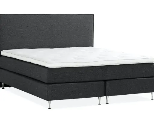 En mörkgrå, modern kontinentalsäng med en vit bäddmadrass och eleganta metallben. Denna elite säng är en dröm för alla som söker komfort.