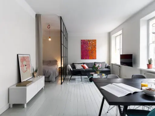 Ljus och modern lägenhet med avdelat sovrum bakom glasvägg. Perfekt kattvind inspiration för små utrymmen.