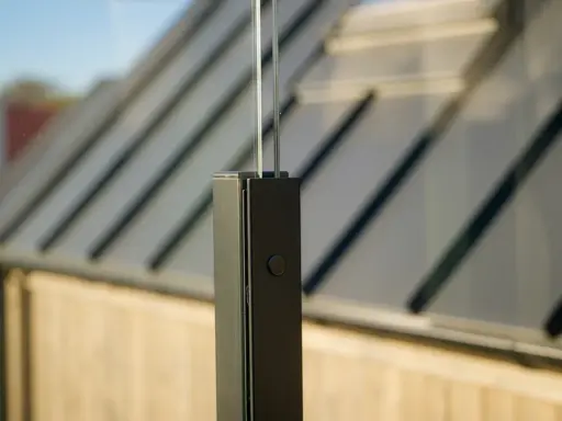 Detaljbild av en stolpe för att montera vindskydd. Glaspanelen syns i bakgrunden.