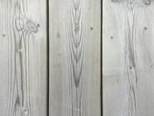 Grå träpanel med tydlig ådring, som efter kiselbehandling altan. Perfekt för en modern och hållbar uteplats.