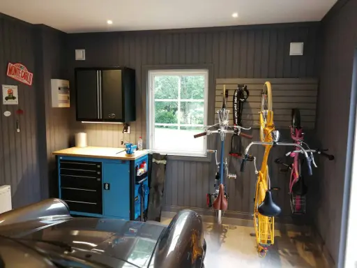 Snygga garage med cyklar upphängda, verktygsskåp och en bil. Perfekt garage inspiration för den som gillar ordning och reda.
