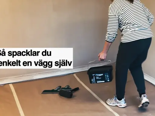 Person med hink med spackel och verktyg för att slipa och jämna ut en vägg.