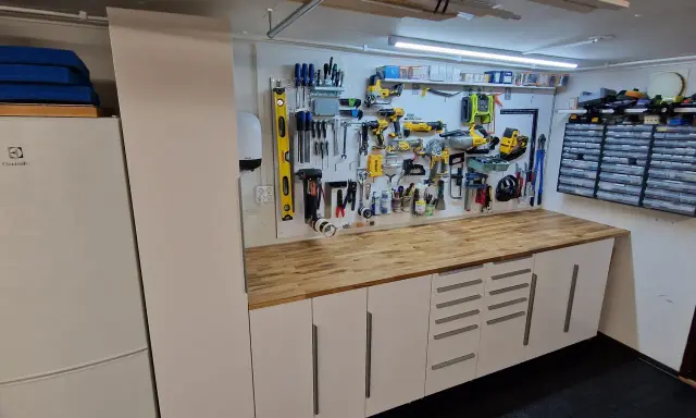 Välordnat garage med verktygstavla, arbetsbänk och förvaringsskåp. Perfekt garage inspiration för den händige.