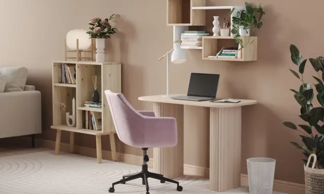 Skrivbord inspo: Ett ljust skrivbord med laptop, en rosa stol och hyllor med växter och böcker. En mysig arbetsplats.
