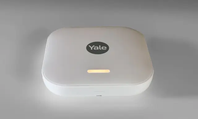 Vit Yale-hub med en lysande indikator, en del av ett modernt garda alarm-system för ökad trygghet.